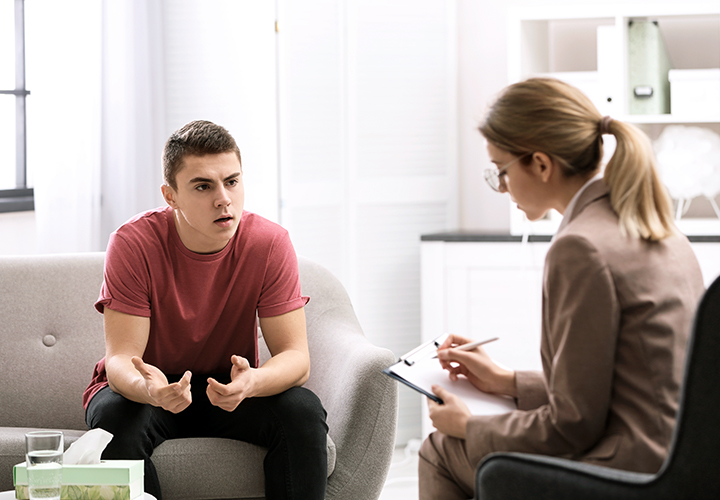 Licensed therapist practicing mindfulness therapy techniques with teen boy